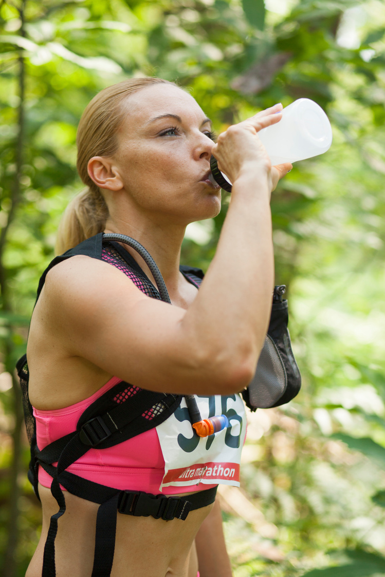 Female cross-country runner drinking water